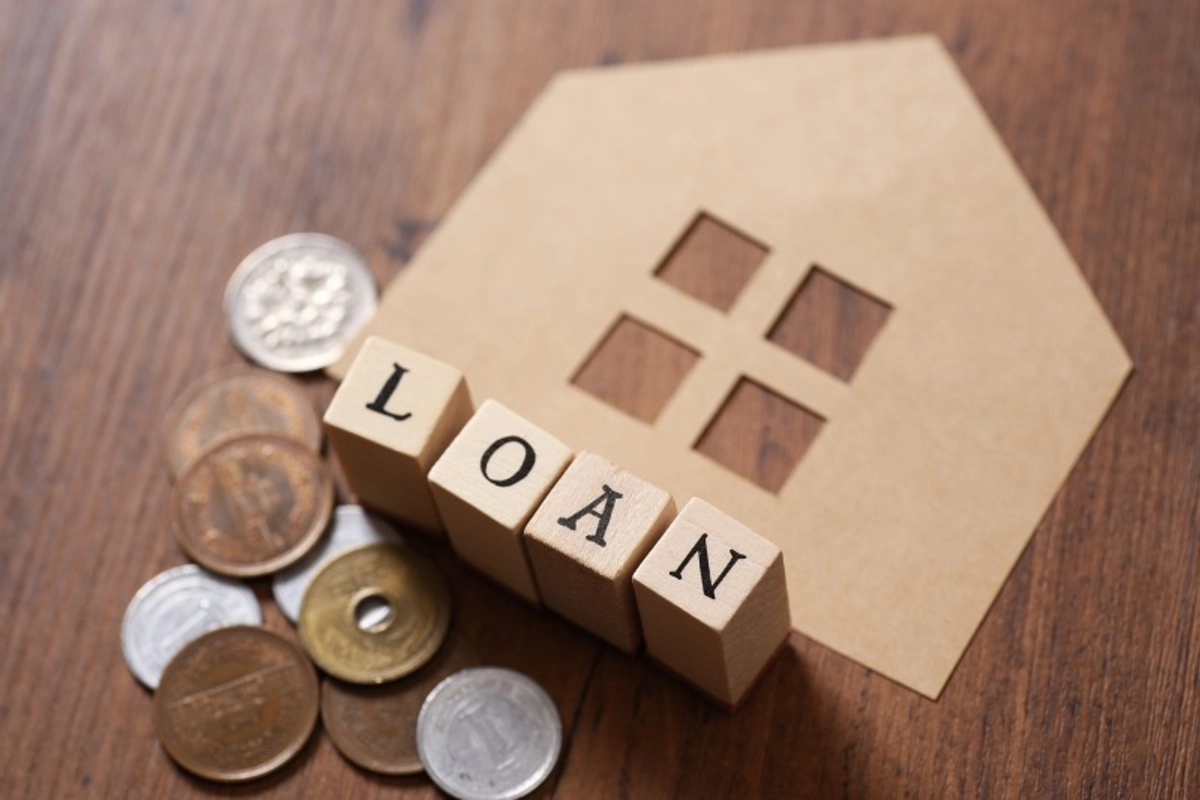 LOANと書かれたブロックと小銭と紙の家