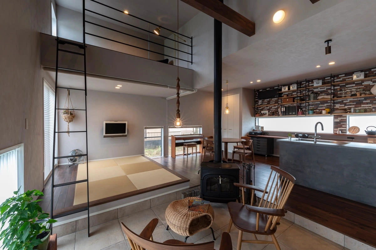 小上がりの畳コーナーと薪ストーブがある落ち着いたリビング