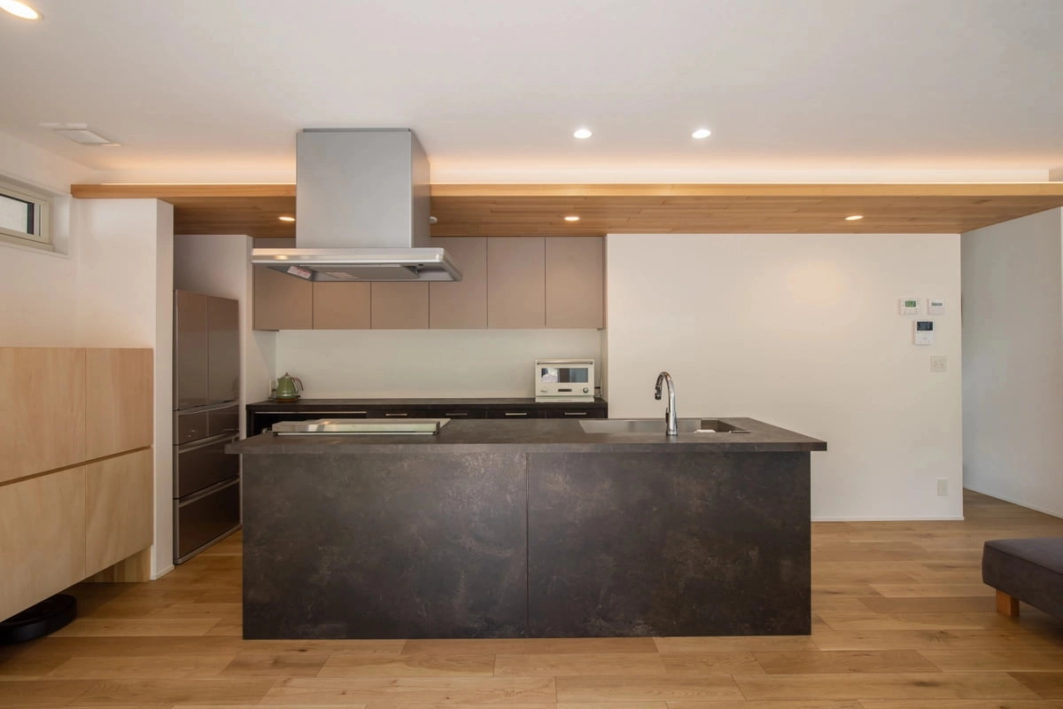 板張りの下がり天井がアクセントになっている黒のスタイリッシュなキッチン