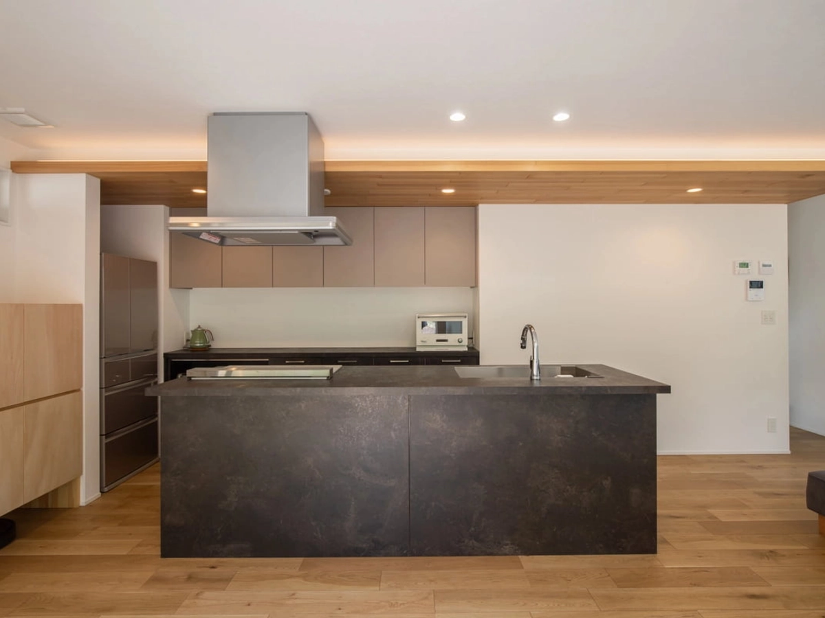 板張りの下がり天井がアクセントになっている黒のスタイリッシュなキッチン