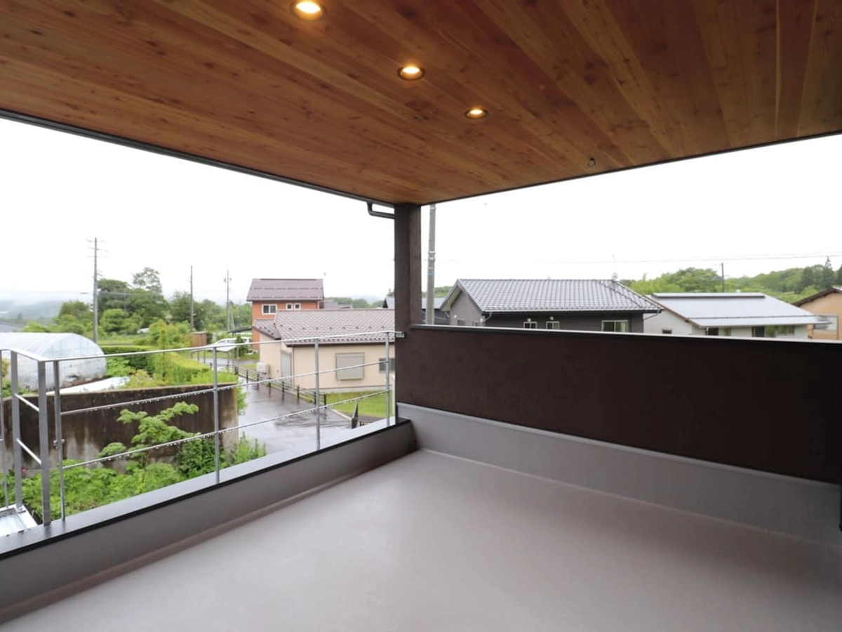 天井を木目にして、あたたかみのある色のダウンライトを採用したバルコニー