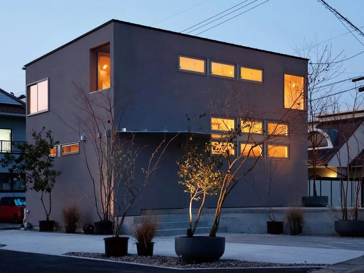 暖色の明かりがともる家の外観