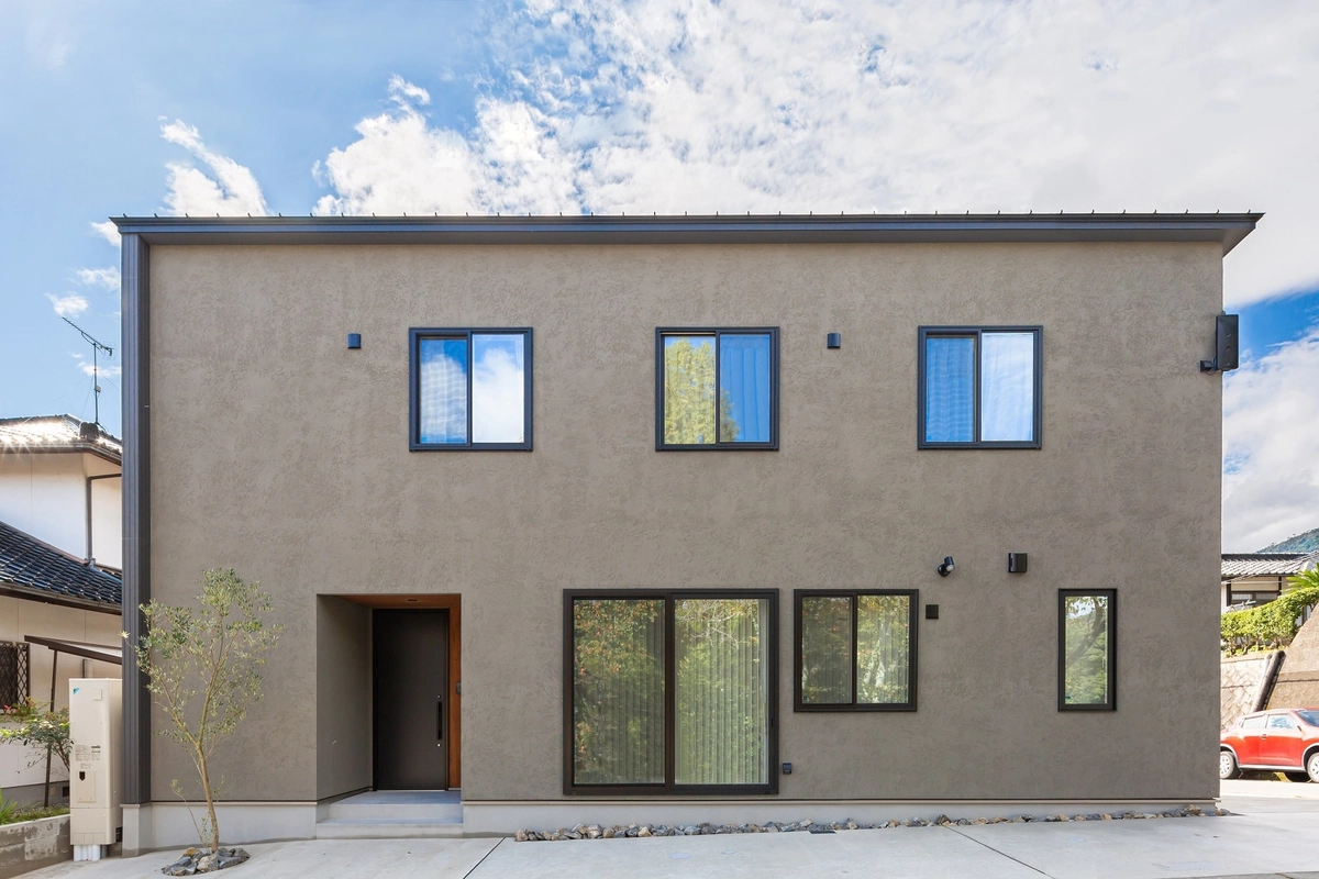 窓が並ぶベージュの外壁の家