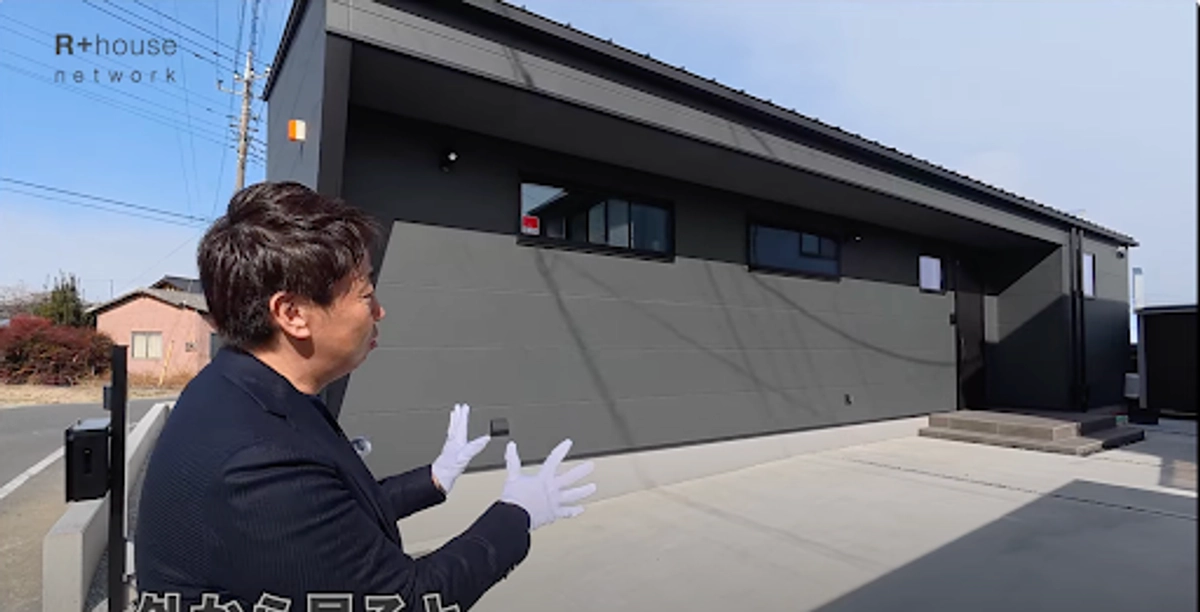 大田さんとグレーの外観の家