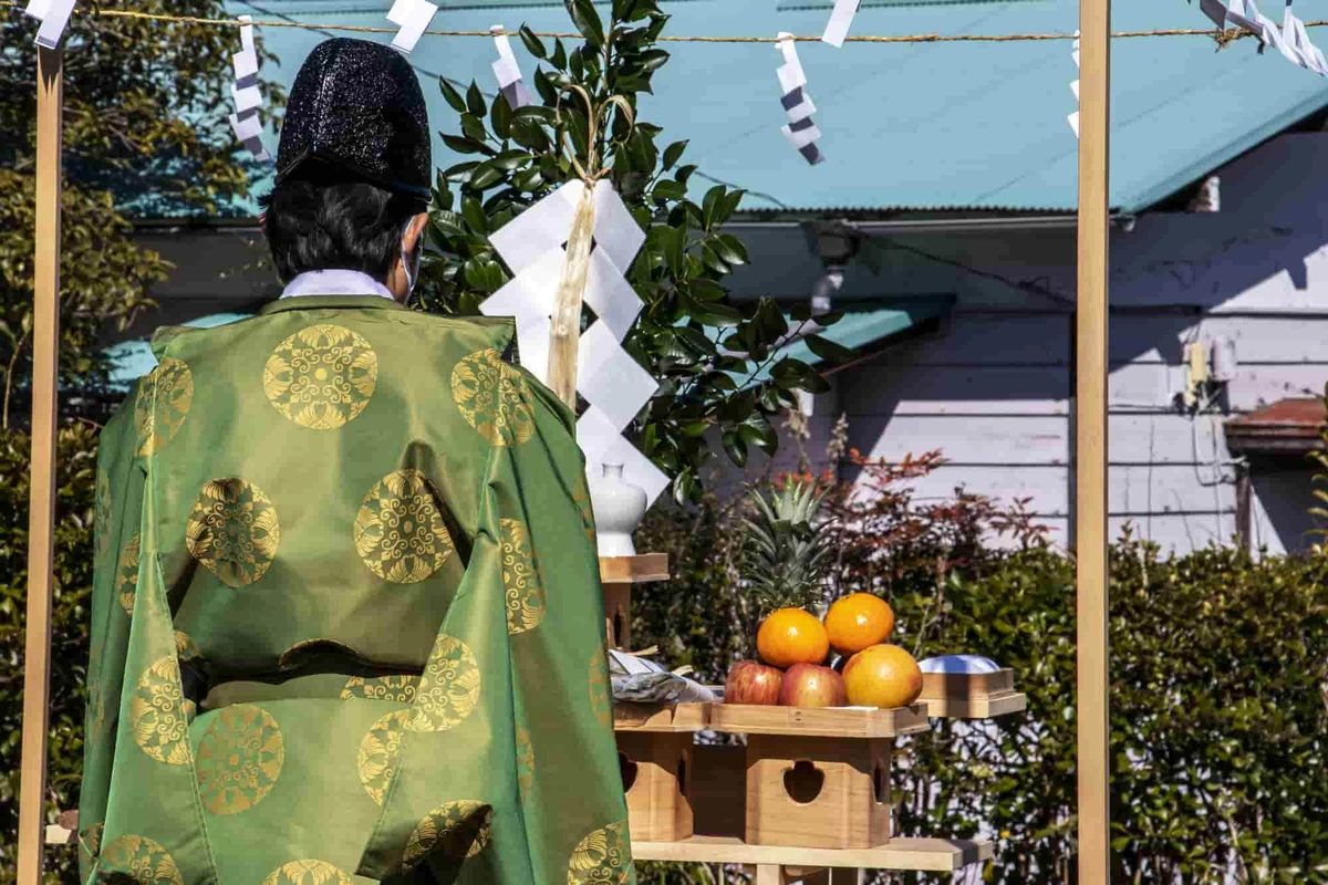 地鎮祭で祭壇に向かい建築工事の安全祈願を祈祷する神主