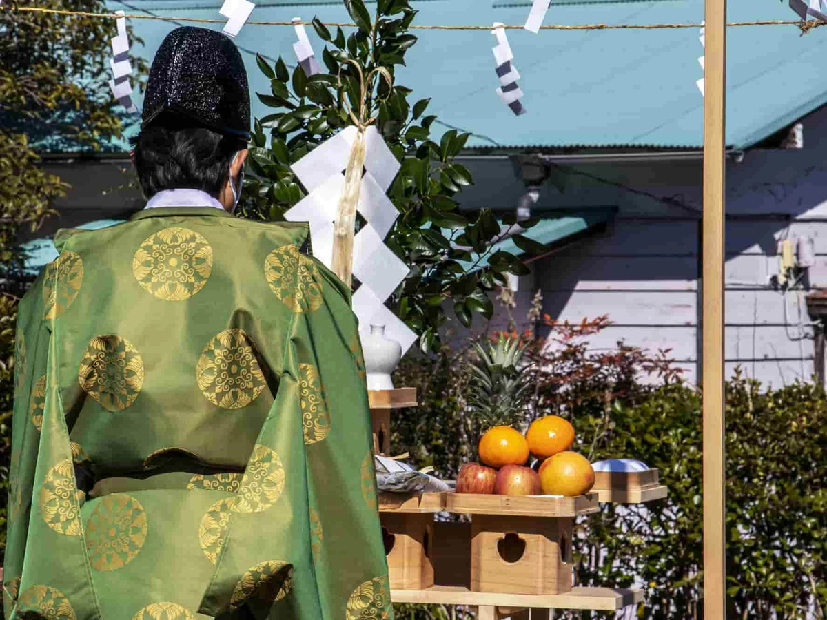 地鎮祭で祭壇に向かい建築工事の安全祈願を祈祷する神主