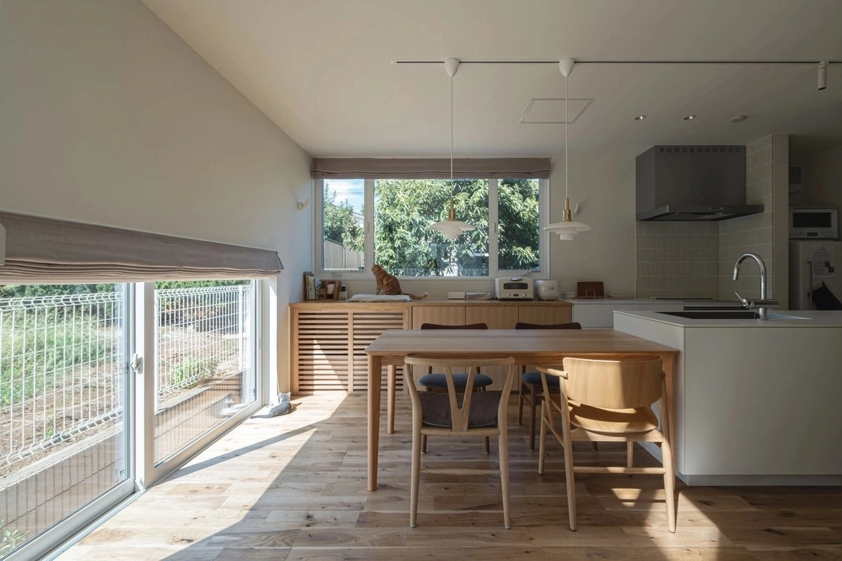 木のダイニングセットと白いペニンシュラキッチンがあるLDK