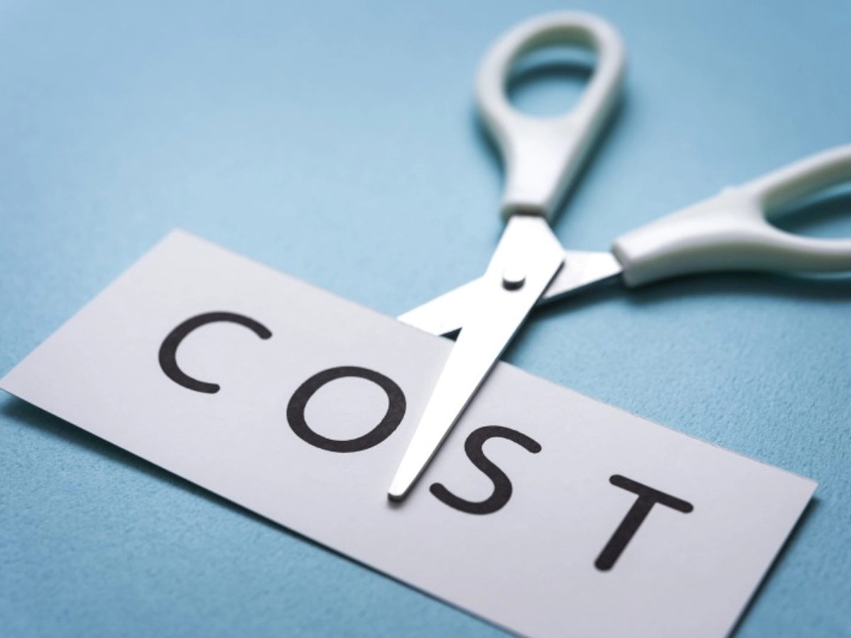 コストと書かれた紙を切ろうとしているハサミ