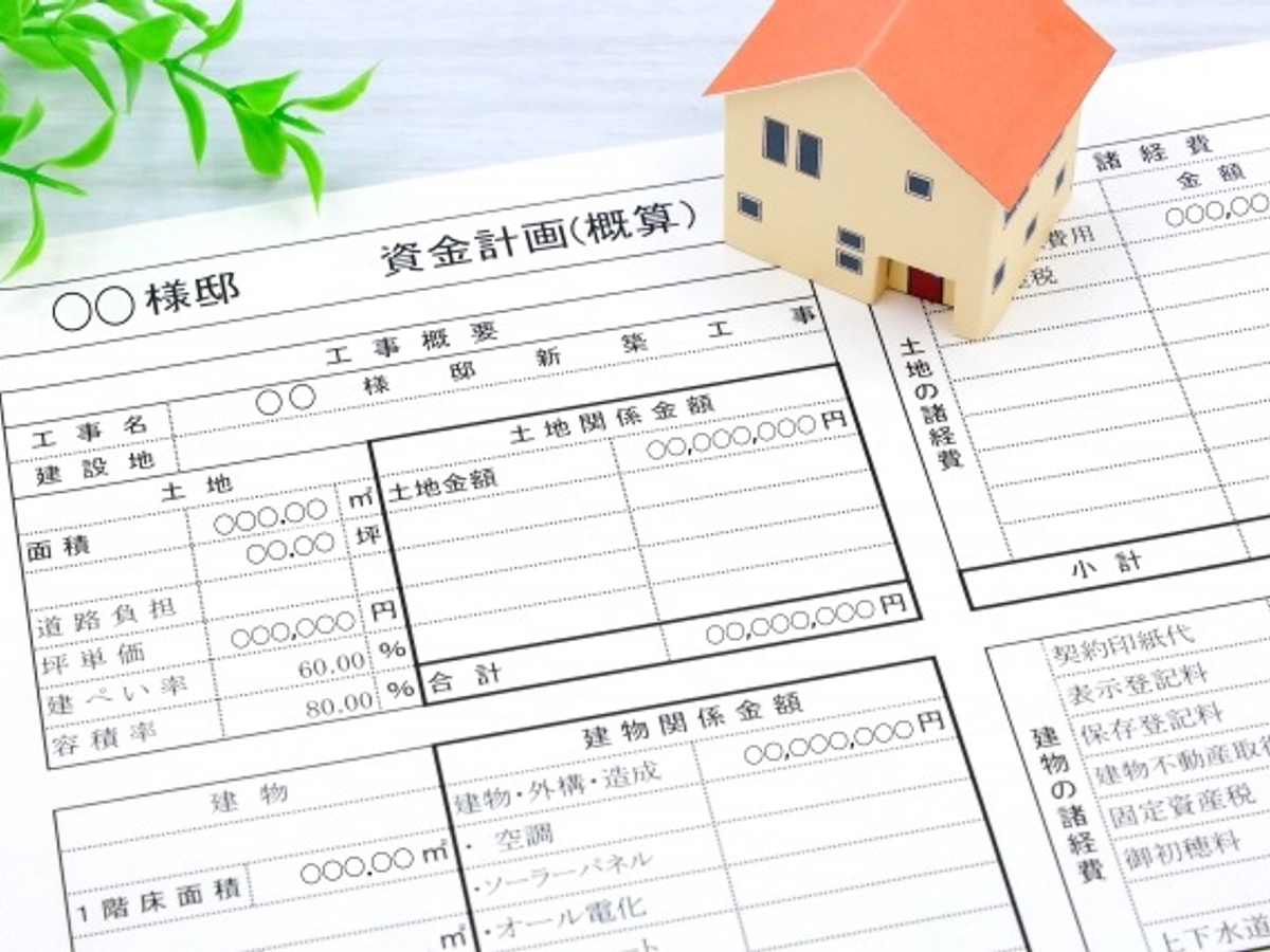 資金計画書の上にオレンジの屋根の家