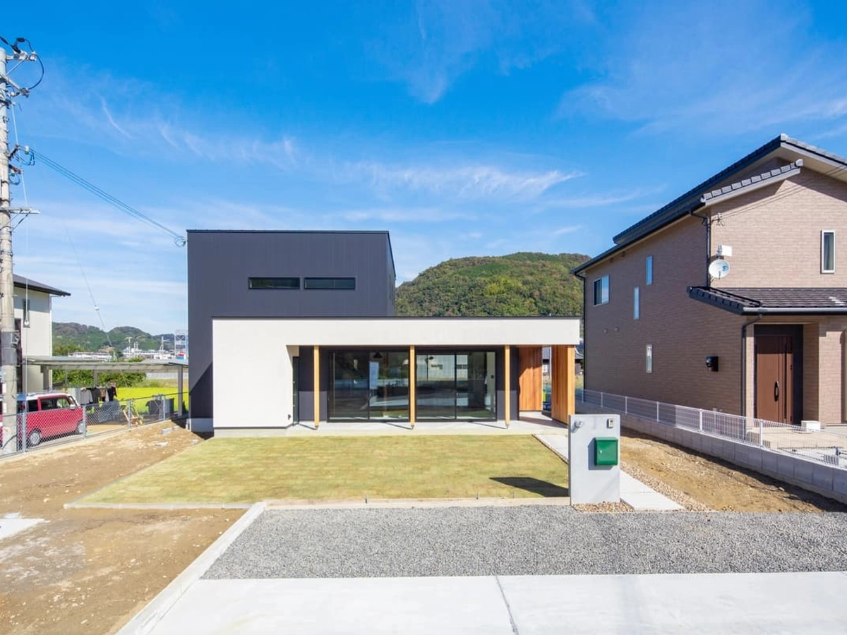 深い軒が印象的な白とグレーの外壁の家