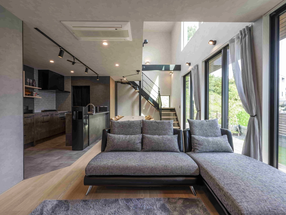 グレーのソファーがある大きな窓に面したリビング