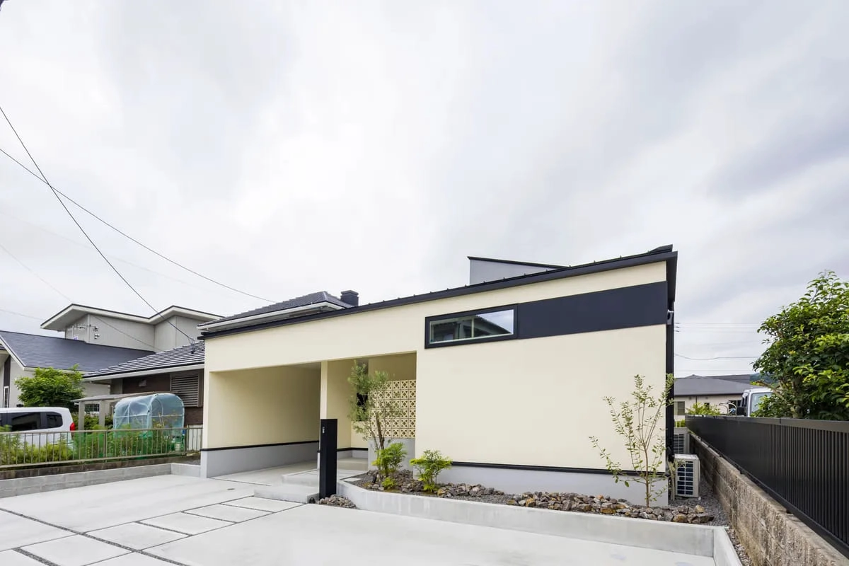 ベージュの壁に黒のラインが映えるモダンな平屋の外観