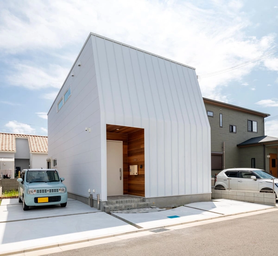 絶妙な折れ具合が印象的な白い外観の家