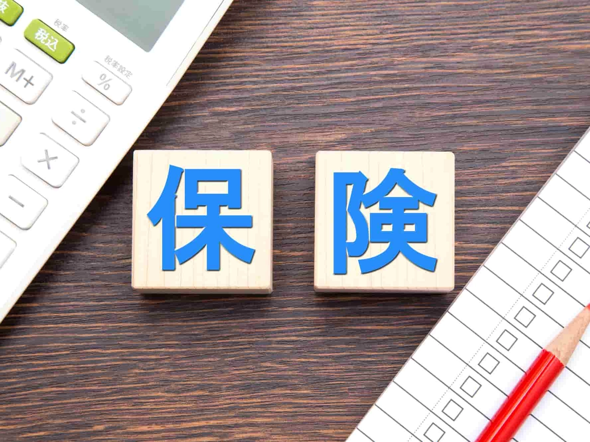 保険と書かれたブロックと電卓とチェックリスト