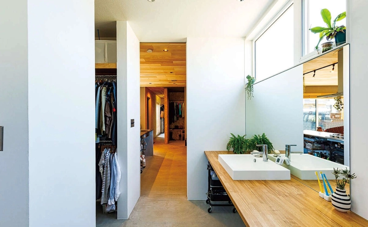 大きな鏡と木製カウンターを配した清潔感のある洗面スペース