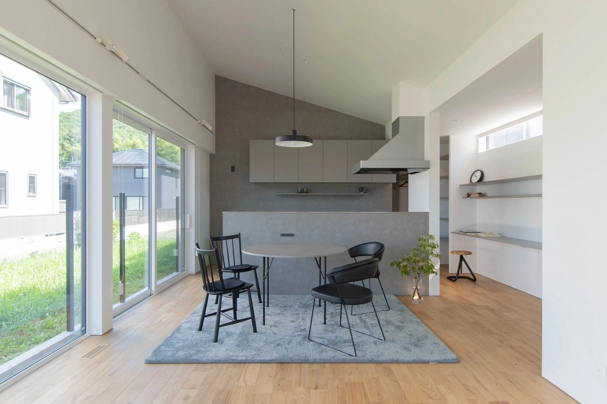 グレーの壁と円形テーブルが映えるモダンなダイニング