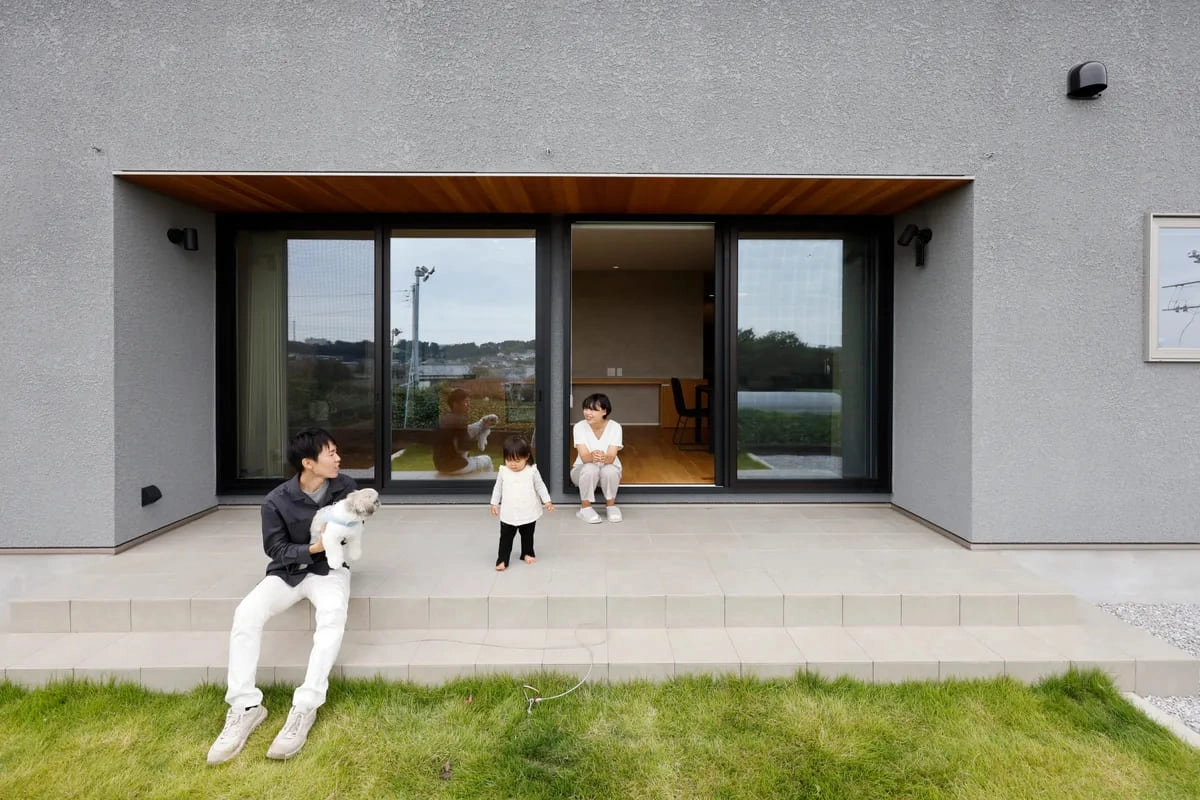 タイルテラスで犬と寛ぐ家族の和やかな日常風景