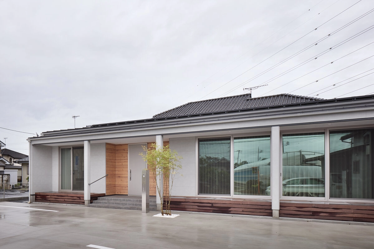 大きな窓と深い軒が特徴的な木目アクセントの平屋の二世帯住宅