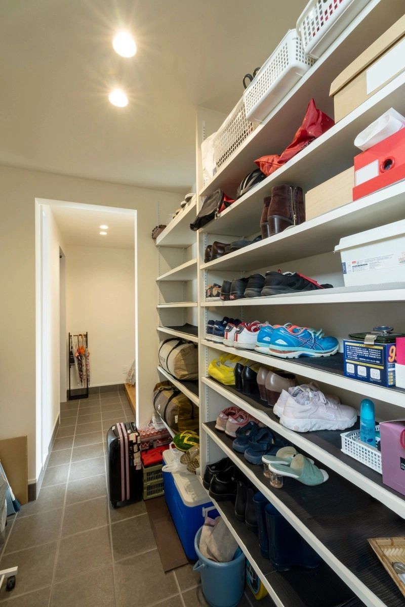 可動棚に靴やバッグが整理された広々とした土間収納