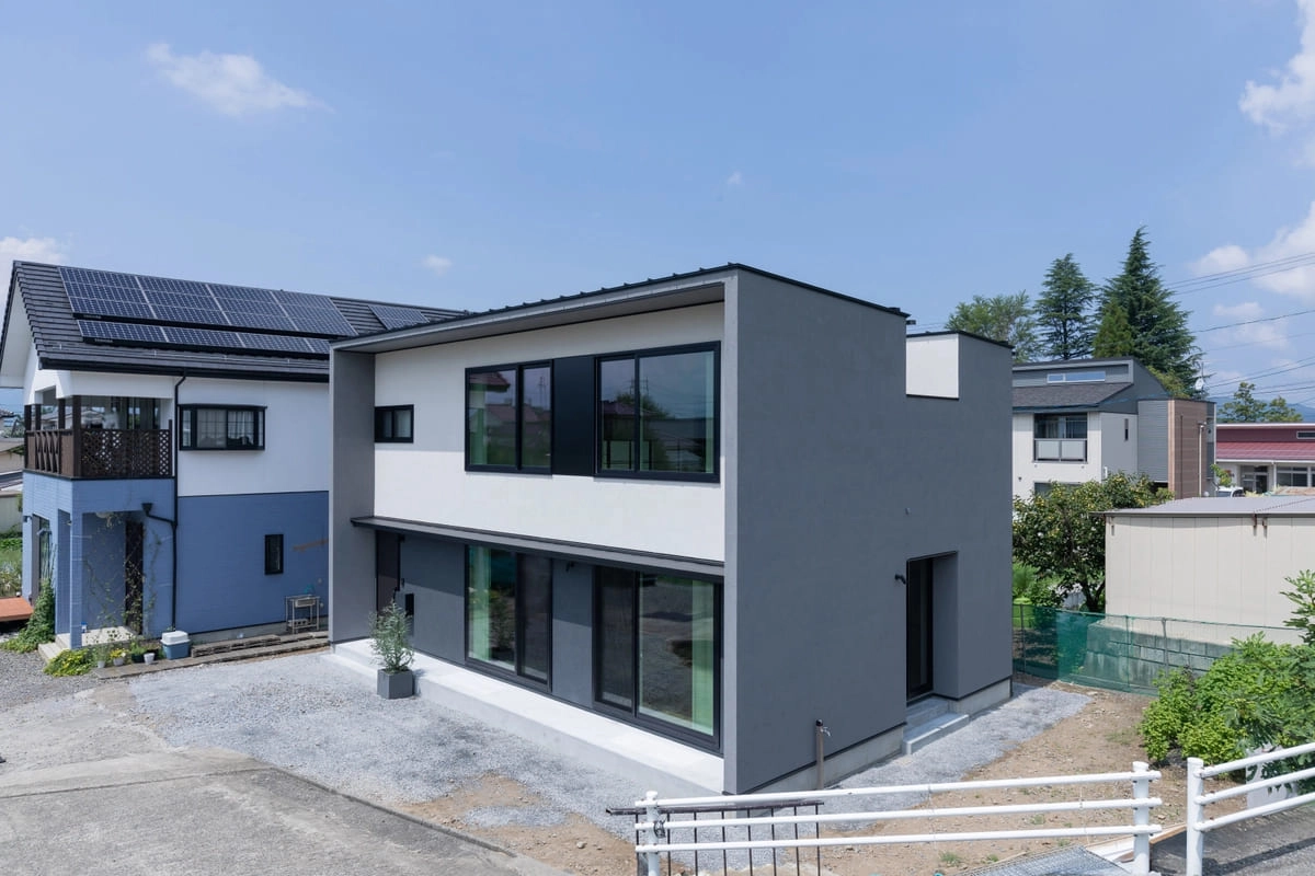 ツートンカラーの外壁と大きな窓が印象的な住宅の外観