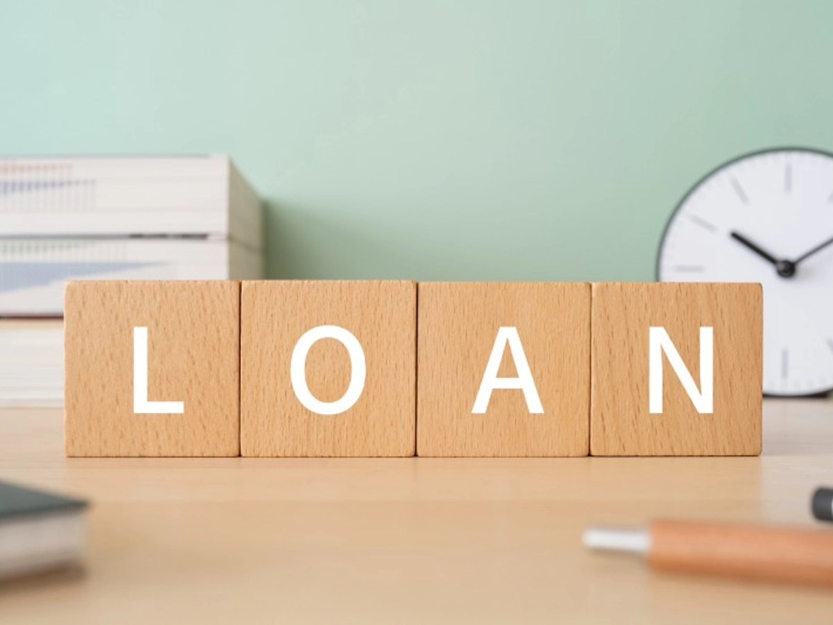 「LOAN」と書かれた積み木ブロックが置かれたデスク
