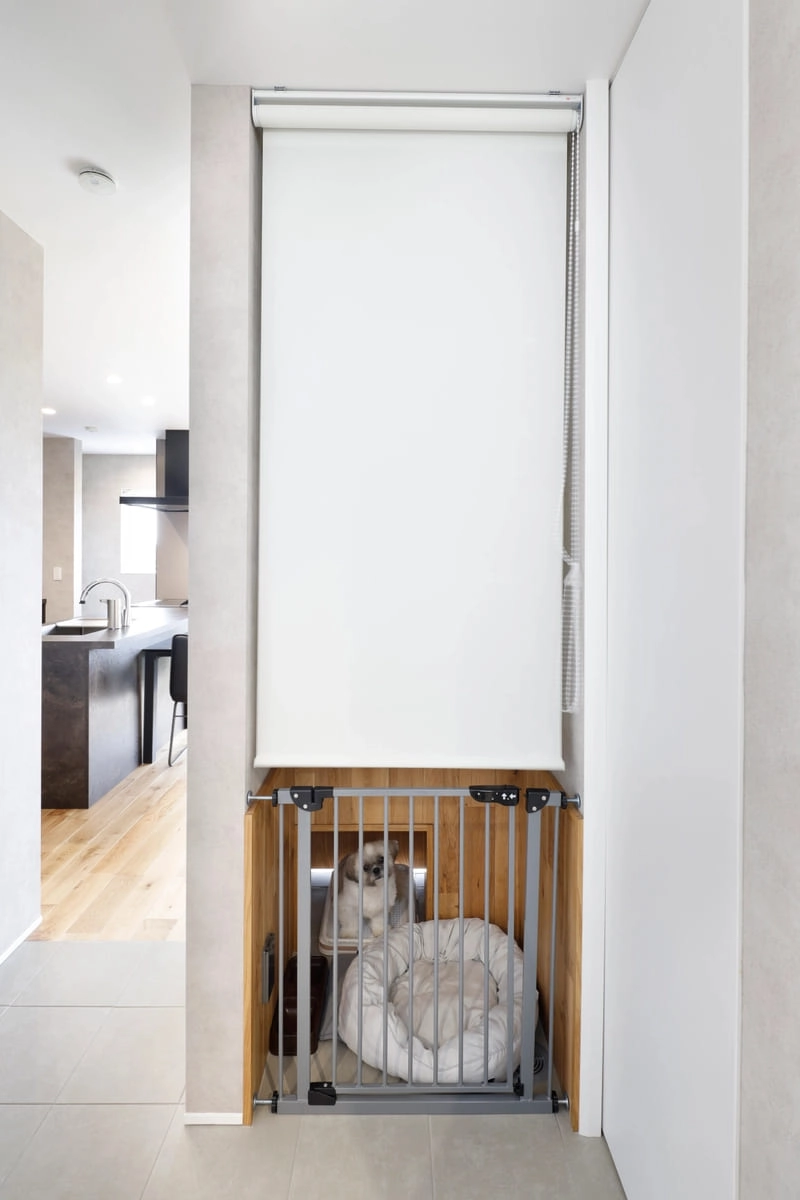ロールスクリーンと柵で仕切られた階段下のペットスペース