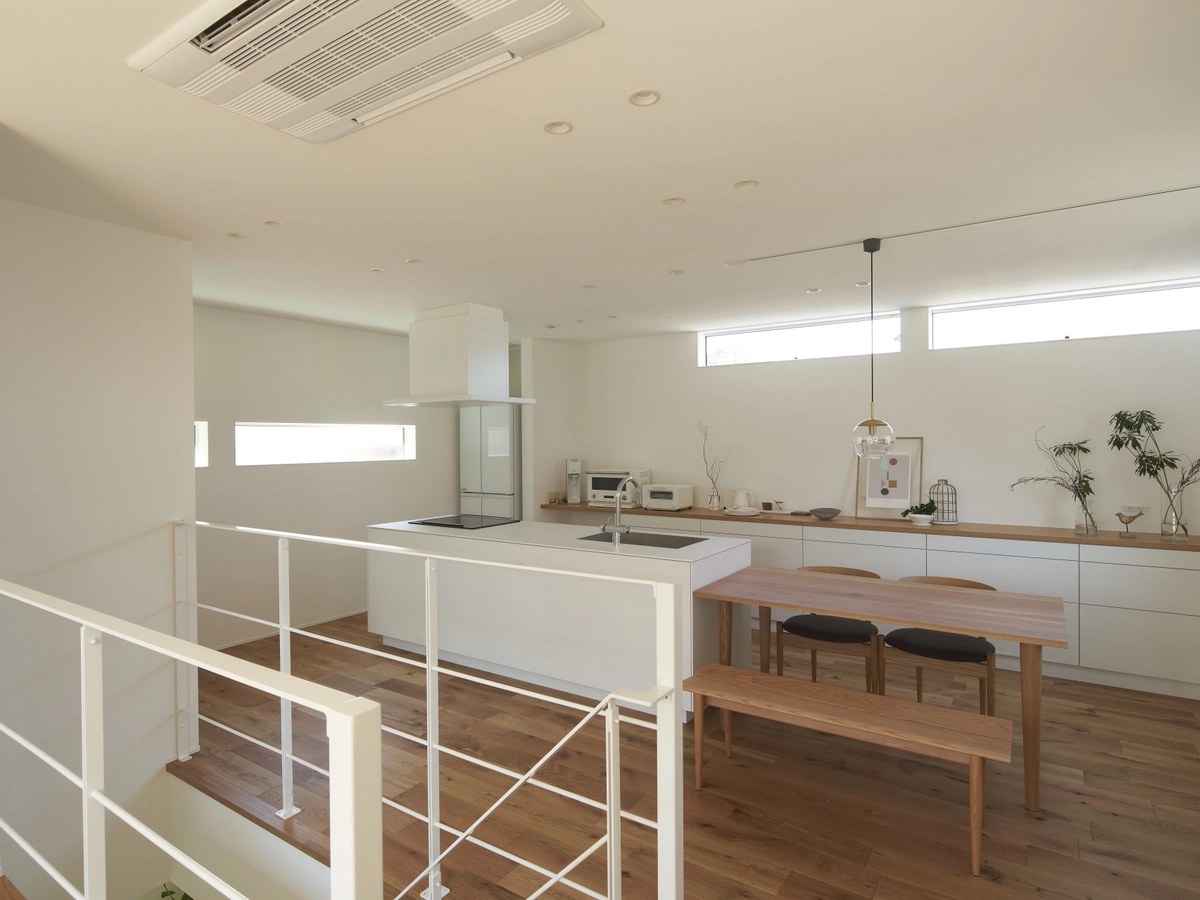 ダイニングテーブルが横にある白くて広々したキッチン(ななめ)