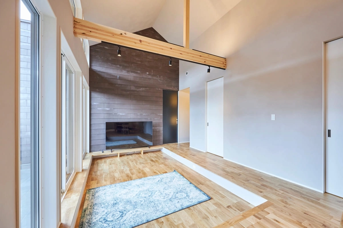 木の梁とタイル壁がアクセントの開放感あふれるリビング