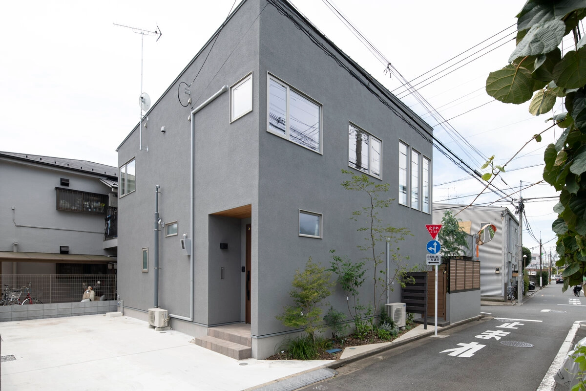 グレーの外壁が特徴的な四角い2階建て住宅の外観