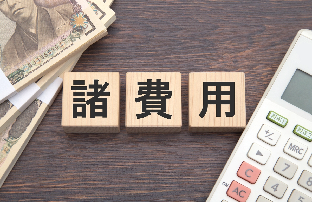 諸費用と書かれたブロックと電卓と現金