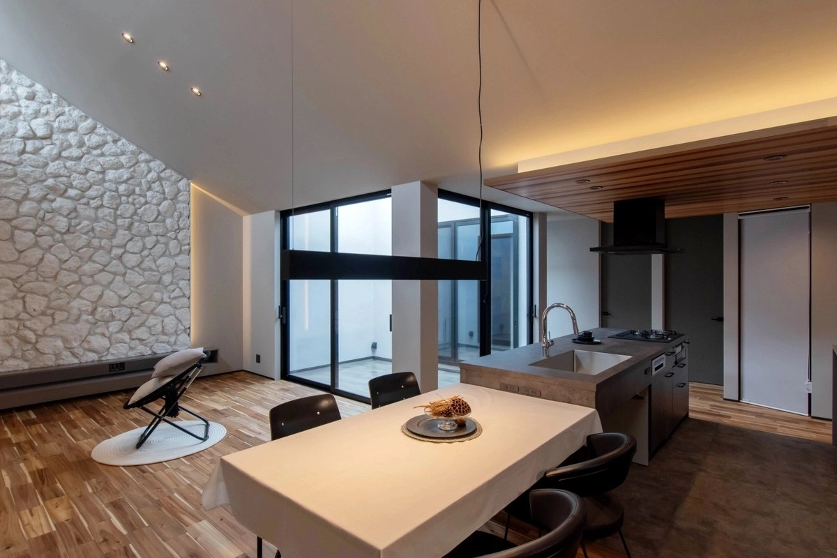 石積みの壁とアイランドキッチンがあるモダンなダイニング