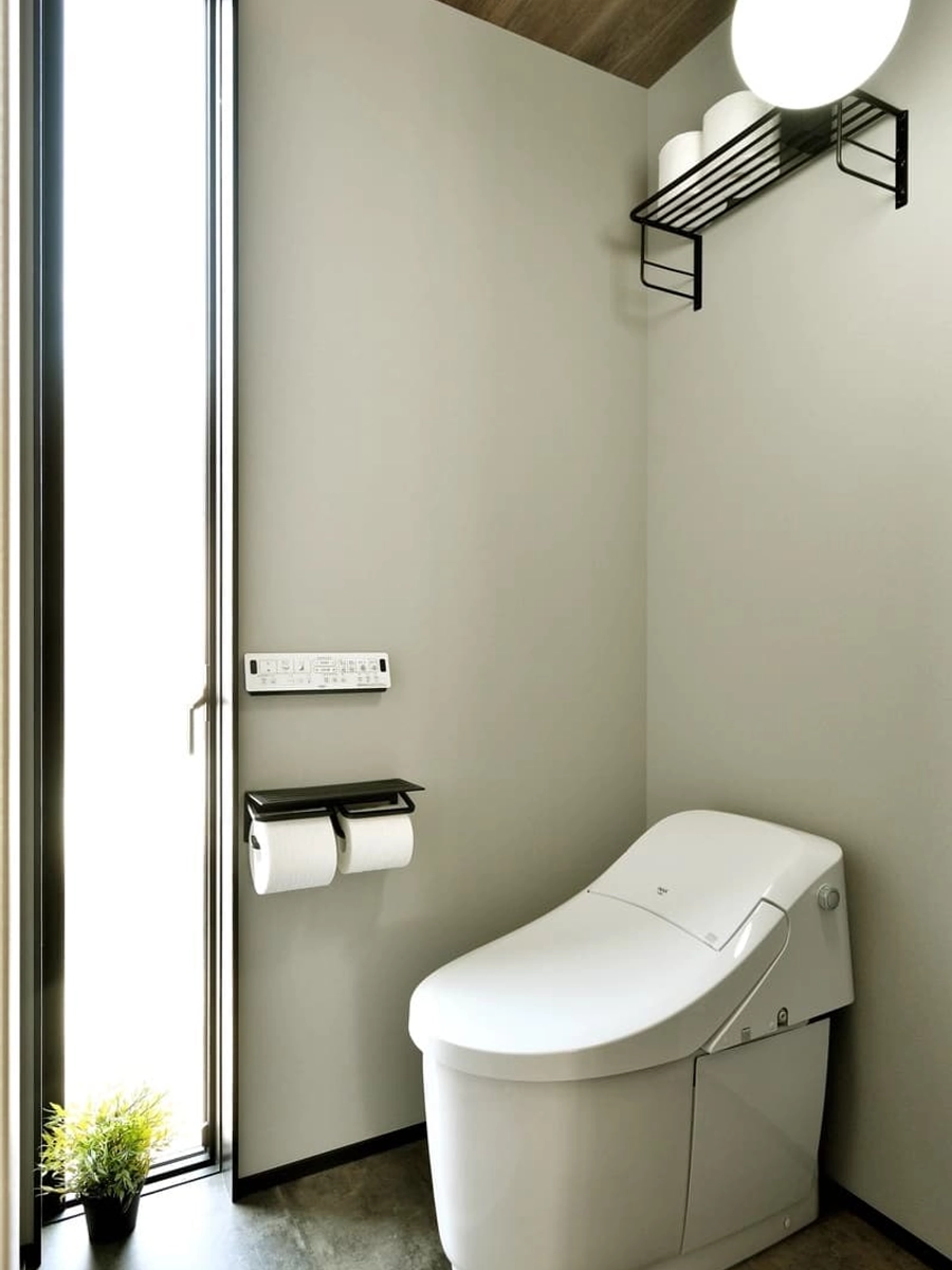 天井から床にかけて細長いFIX窓を採用したトイレ