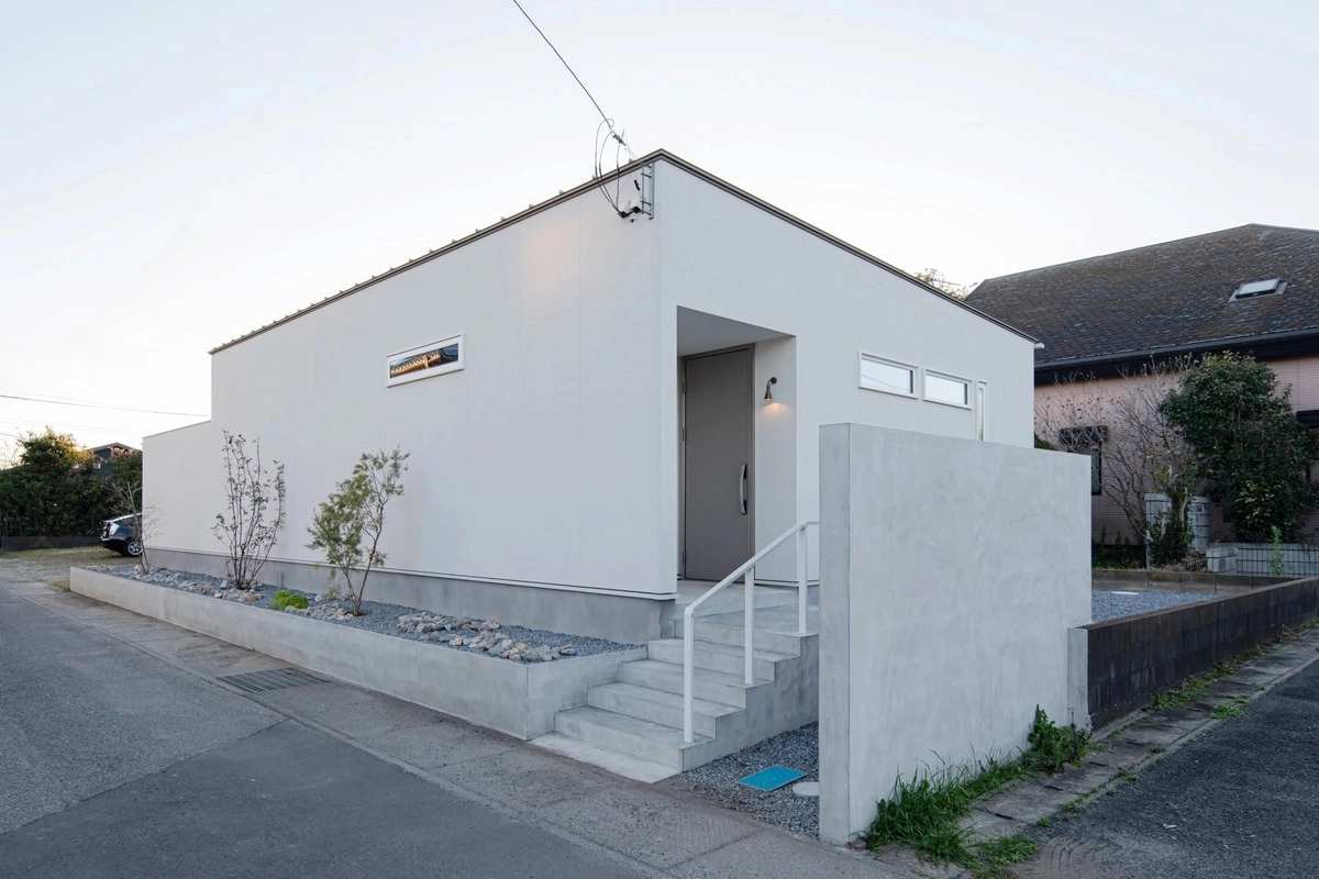 白い外壁にコンクリート塀が映える平屋のミニマルな外観