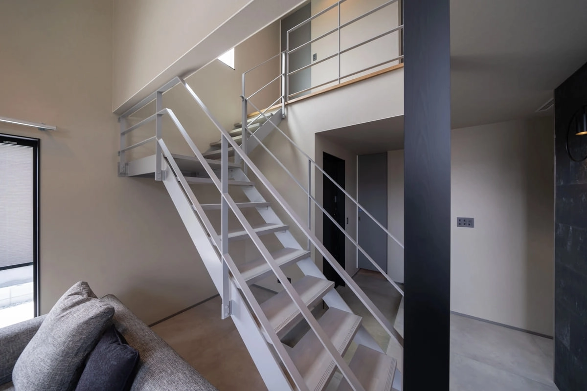 白い鉄骨階段とグレーの内装が広がる空間