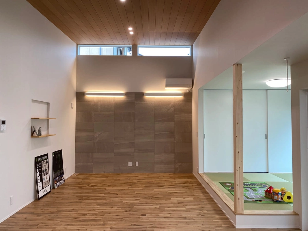 高窓から光が差し込む高天井のリビングと小上がりの畳