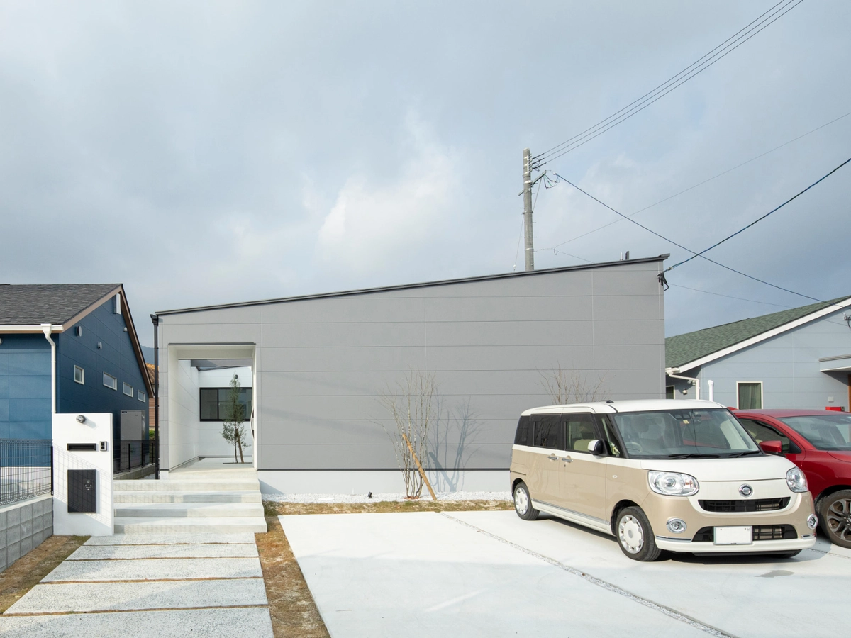 グレーの外壁の平屋と玄関アプローチ