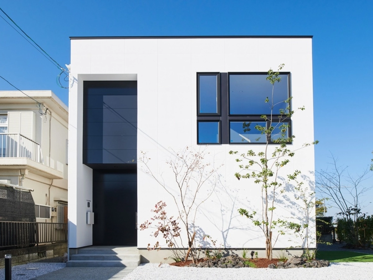 2階の大きな窓が印象的な白い外観の家