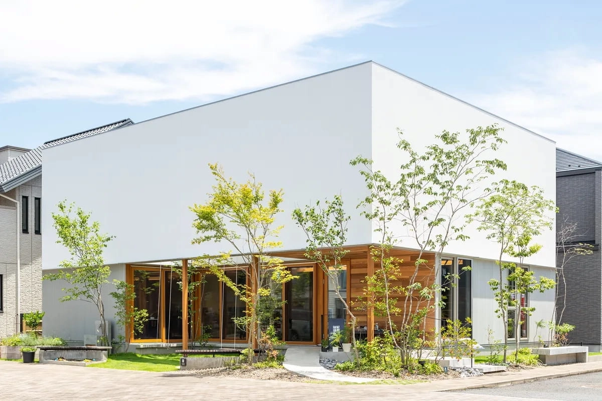 木のぬくもりを感じるテラスがある白い箱型の住宅