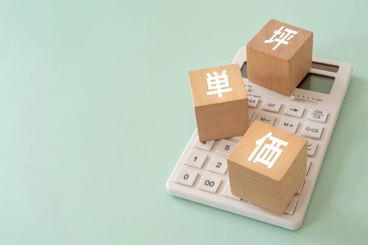 坪単価と書かれた積み木と電卓