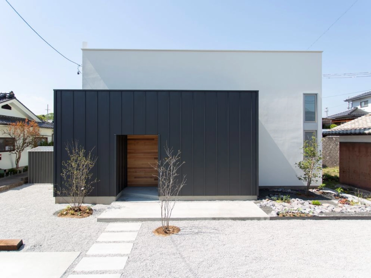 観葉植物がある白とグレージュカラーがオシャレな外観