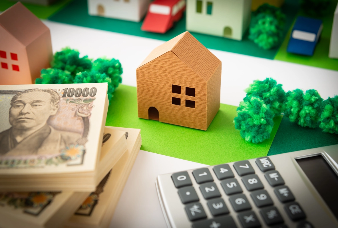 現金と家の模型と電卓