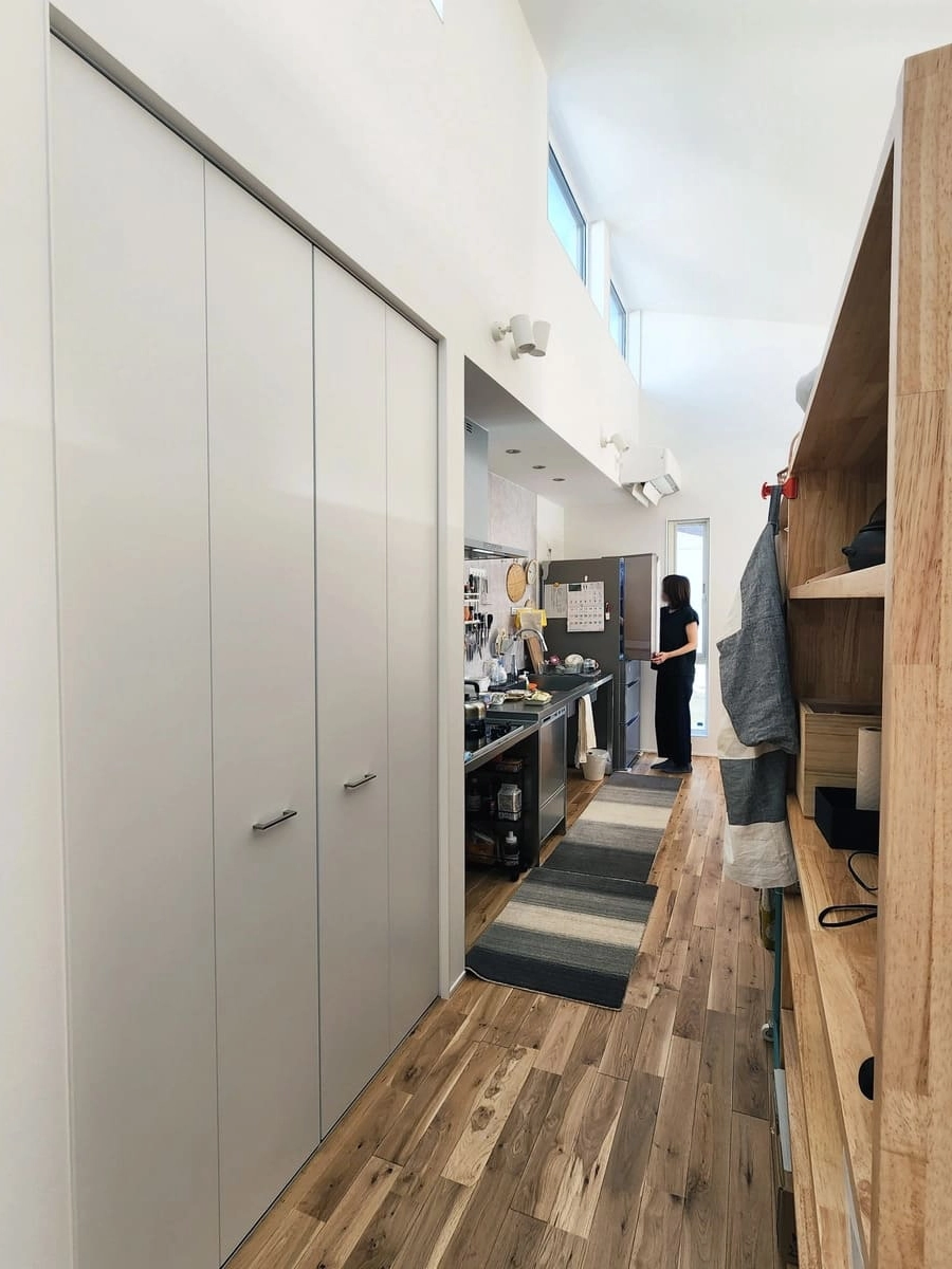 キッチン横の扉付き収納と向かいの造作棚