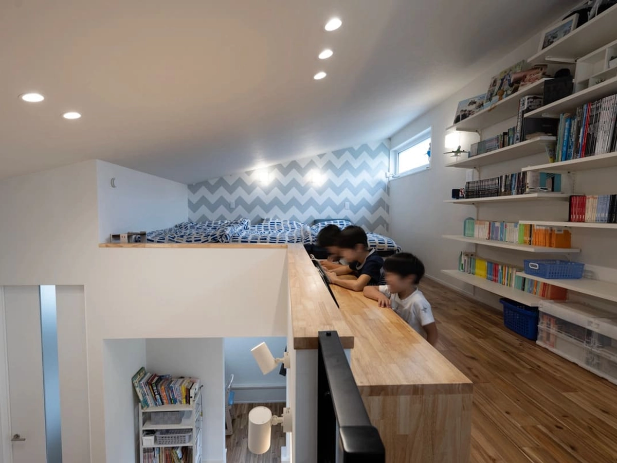 階段横の机に座る3人の子供