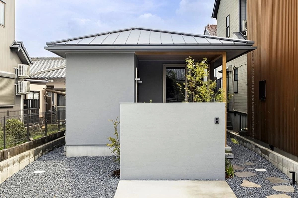 アプローチに目隠し壁のあるグレーの平屋