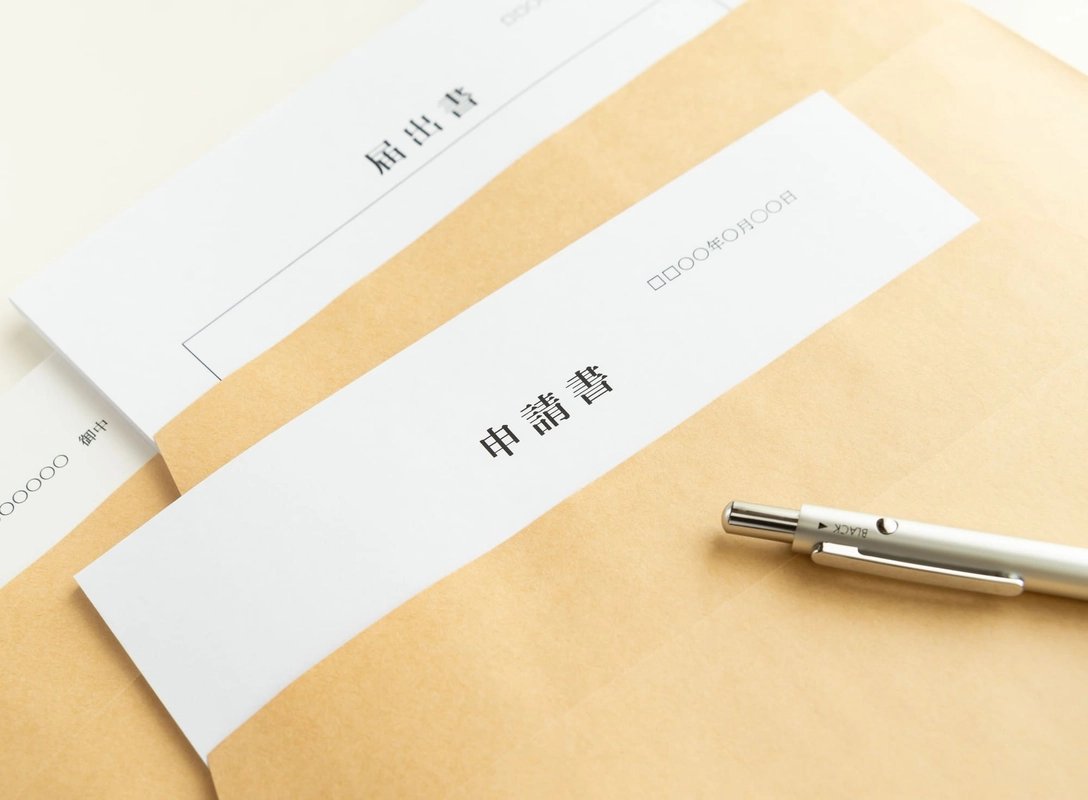 封筒に入った届出書と申請書とペン