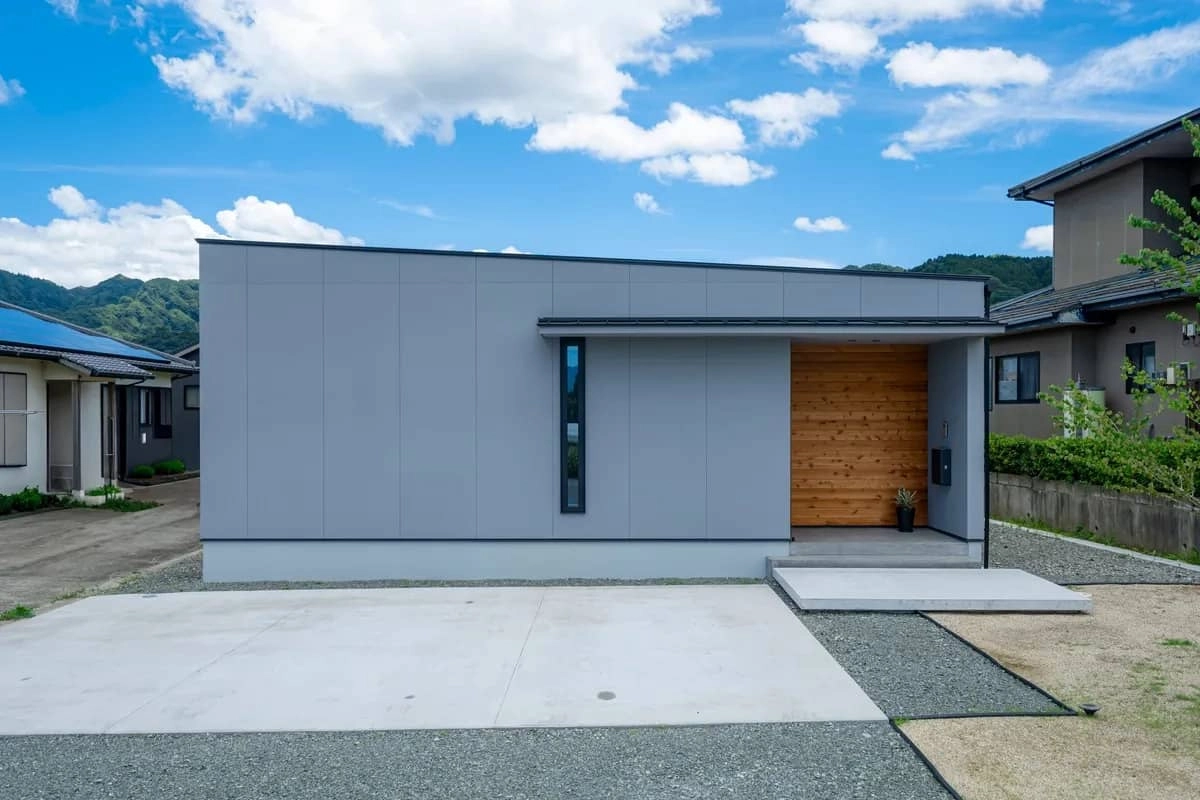 玄関周りの板張りがアクセントになったグレーの平屋