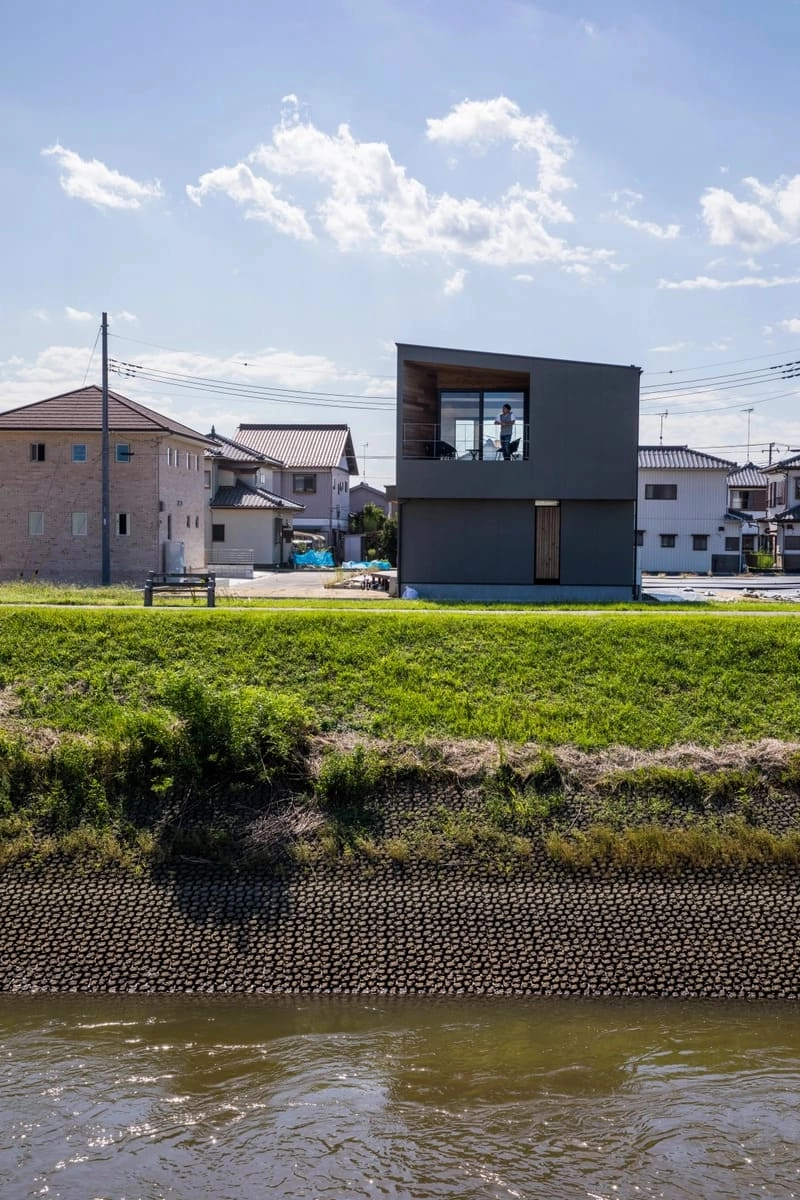 川と奥のグレーの外観の家