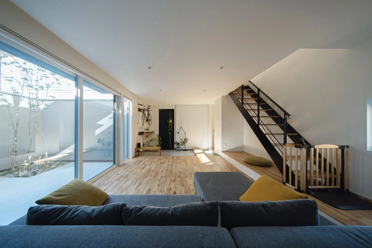 吹き抜けから光が降り注ぐヘリンボーン床と鉄骨階段が印象的な開放感あるLDK