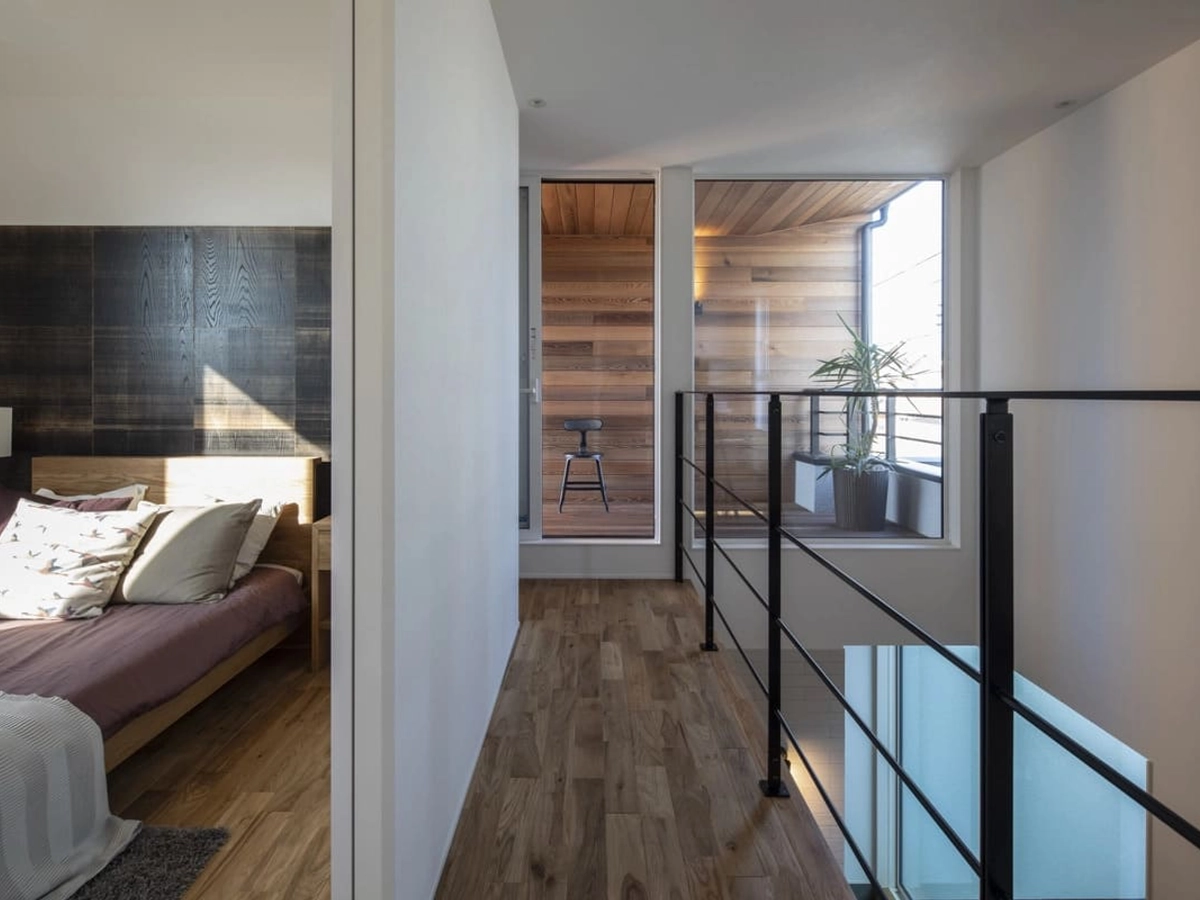 大きなガラスと吹き抜けが室内に光を取り込む二階寝室