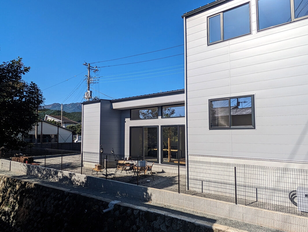 高台にあるグレーの外壁のモダンな住宅の外観